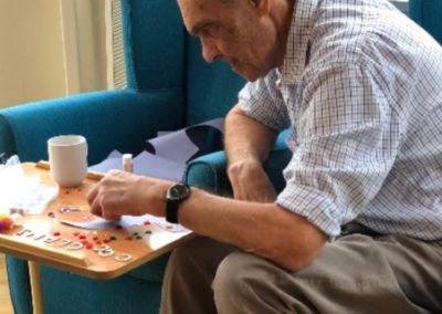 Bromley Park Care Home male resident making Halloween decorations with arts and crafts materials