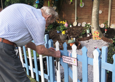 Male resident looking at the fairy garden at Bromley Park Care Home