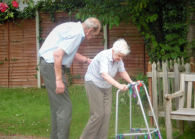 A Bromley Park Care Home resident assists another resident out in the garden
