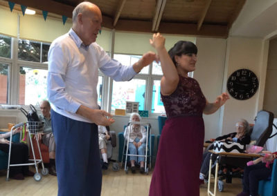 A singer and gentleman resident dancing together at Bromley Park Care Home