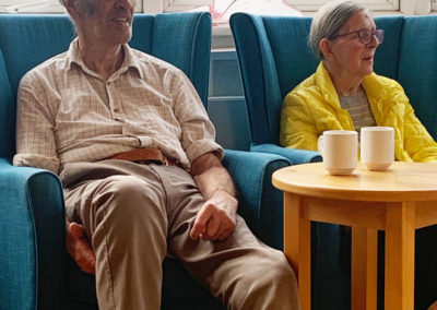 Lady and gent resident listening to music in the conservatory at Bromley Park
