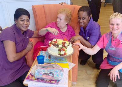 Resident and staff members with a birthday cake