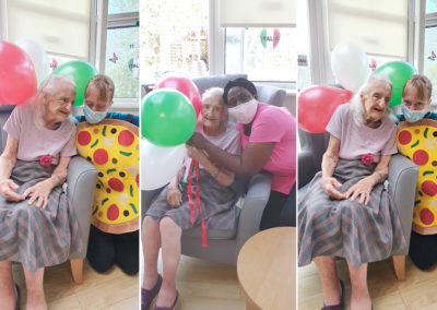 Bromley Park Care Home residents and staff smiling at the camera with balloons and pizza decorations