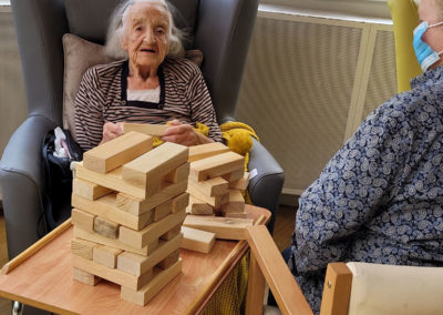 Resident and staff member playing Jenga at Bromley Park Care Home