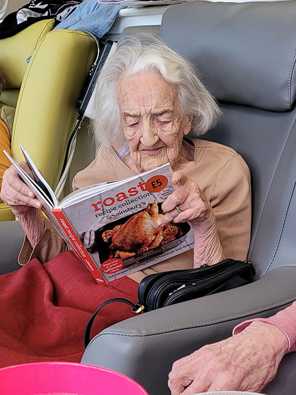 Bromley Park Care Home resident reading a recipe book